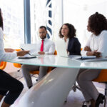 Business leader interviewing job candidate. Business man and women sitting at conference table, using laptops and talking. Discussion agreement concept